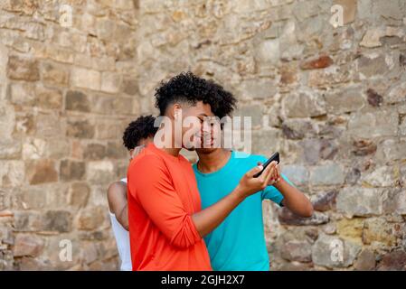 Multiethnic friends using mobile phone in the street Stock Photo