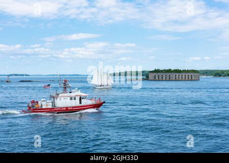 Casco Bay, Maine, USA.  Fire boat and Fort Gorges, a former United States military fort built on Hog Island Ledge at the entrance to the harbor at Por Stock Photo