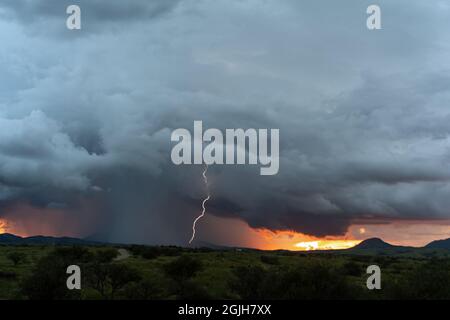 Lightning and storm clouds at sunset Stock Photo