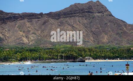 View of a crowded Waikiki Beach and Diamond Head crater in the distance Stock Photo