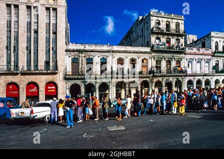 Cubans in long queue waiting for a shared taxi, central Havana, Cuba Stock Photo