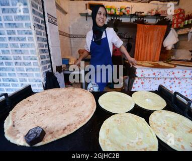 Moroccan women preparing traditional Moroccan bread in a small shop at the Salé medina, Morocco. Stock Photo