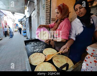 Moroccan women preparing traditional Moroccan bread in a small shop at the Salé medina, Morocco. Stock Photo