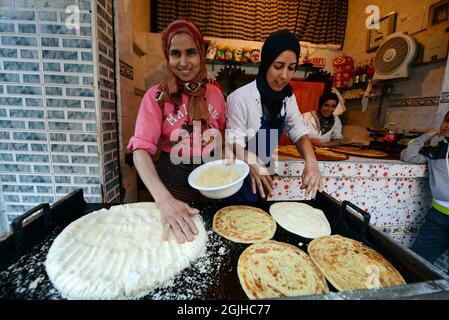 Moroccan women preparing traditional Moroccan bread in a small shop at the Salé medina, Morocco. Stock Photo