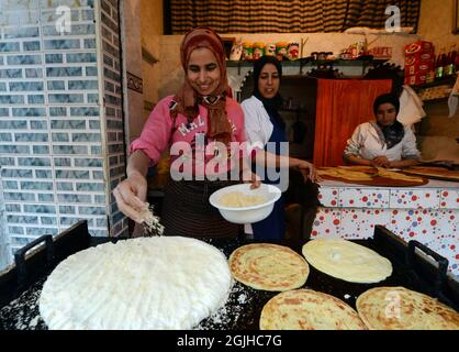 Moroccan women preparing traditional Moroccan bread in a small shop at the Salé medina, Morocco. Stock Photo