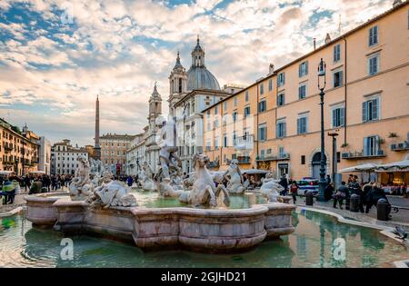 The Fountain of Neptune at the north end of Piazza Navona with the church of Sant'Agnese in Agone and the Egyptian obelisk in the background. Stock Photo