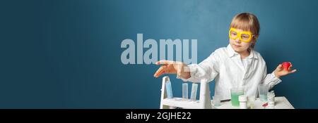 Young kid testing chemistry lab experiment on blue banner background Stock Photo