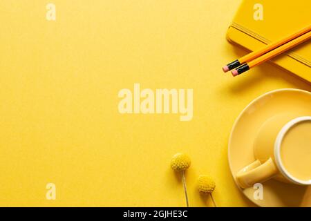 Notebook, pencil, coffee cup on yellow background. flat lay, top view, copy space. workspace Stock Photo