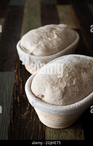Bread dough in a rattan basket on a table made of wood Stock Photo
