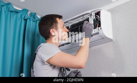 Concentrated electrician fixes electrical circuit panel Stock Photo