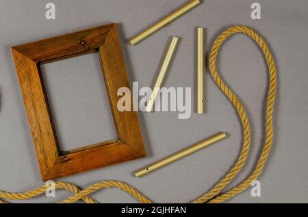 Empty photo frame and rope against a gray background. Wooden pic Stock Photo
