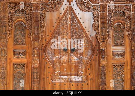 The pattern of carving wayang gunungan on the door of an Indonesian wooden house, with an artistic and classy traditional ethnic feel. Stock Photo