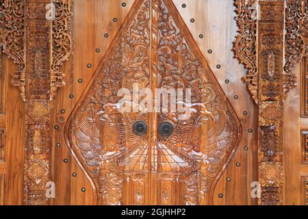 The pattern of carving wayang gunungan on the door of an Indonesian wooden house, with an artistic and classy traditional ethnic feel. Stock Photo