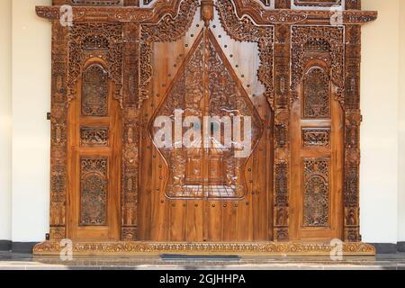 The pattern of carving wayang gunungan on the door of an Indonesian wooden house, with an artistic and classy traditional ethnic feel. Stock Photo