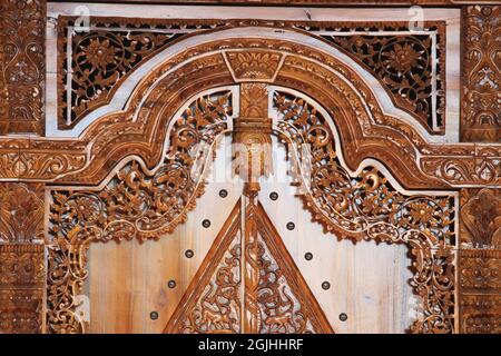 The pattern of carving wayang gunungan on the door of an Indonesian wooden house, with an artistic and classy traditional ethnic feel. Stock Photo