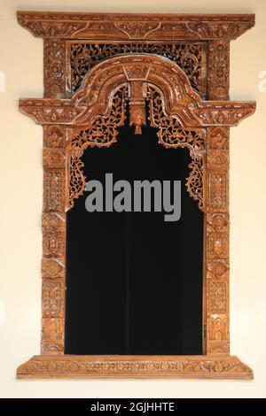 The pattern of carving wayang gunungan on the door of an Indonesian wooden house, with an artistic and classy traditional ethnic feel. Stock Photo