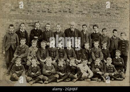 In late 19th century Dublin, schoolboys and their bearded schoolmaster keep as still as possible for a formal photograph.  June 1894 at St Stephen's Parochial School, 2 - 8 Northumberland Road, Ballsbridge, Dublin, Ireland