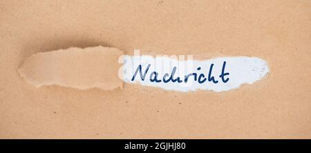 The german word message is stand on an old textured paper, handwritten Stock Photo