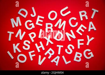Mixed solid letters pile top view photo. Education concept on red background. Stock Photo