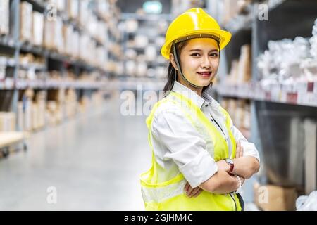 Asian woman warehouse worker are posing and smiling to the camera in a warehouse Stock Photo