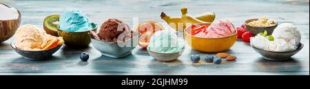 Ice cream scoops with various flavors served in bowl on table with fresh fruits and berries Stock Photo