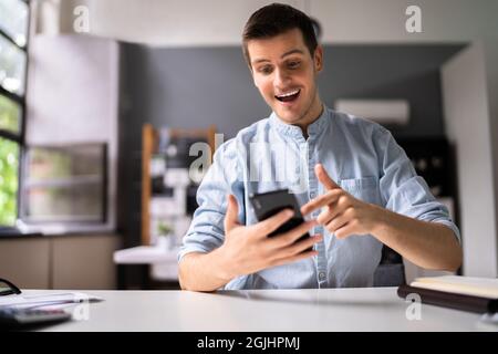 Happy Stock Market Trader Looking At Phone Stock Photo