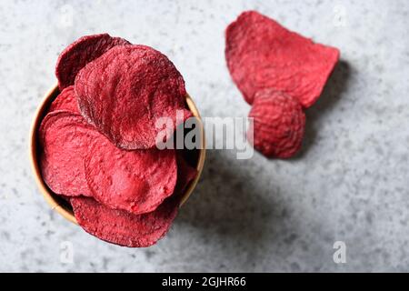Vegetable beetroot chips on a gray background. Vegan snack. Top view. Close up. Copy space. Stock Photo