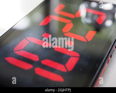 Close-up of a mobile phone screen with the display showing a digital time readout Stock Photo