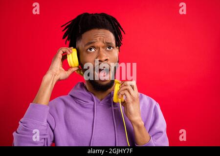 Photo portrait man listening music in headphones dissatisfied isolated vibrant red color background Stock Photo
