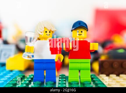 POZNAN, POLAND - Feb 15, 2019: Poznan, Poland - February 15, 2019: Two Lego man figures standing next to each other and holding a drink celebrating. Stock Photo