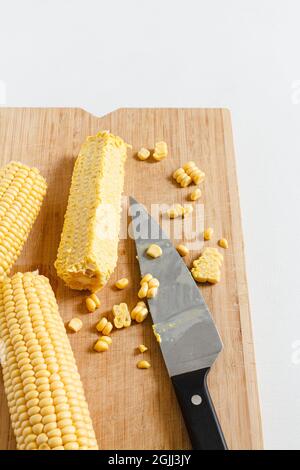 Chopping corn cobs on a wooden board. Stock Photo