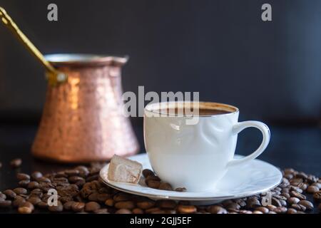 a cup of Turkish coffee. Turkish delight and eans. pot in the background. Selective Focus Cup Stock Photo