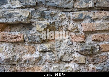 Grey white black red orange old vintage brick wall background. Rustic cemented brick house wall texture with grunge surface. Shabby Building Facade With Damaged Plaster Stock Photo