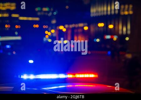 Detail of police car with lights flashing with red and blue colors on blurred background of city street Stock Photo