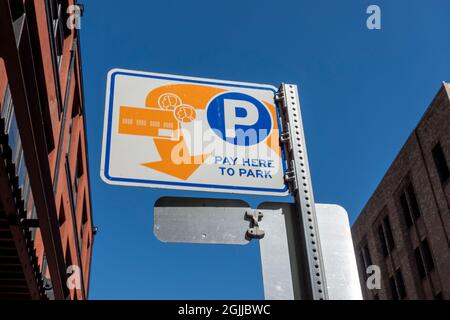 Tacoma, WA USA - circa August 2021: Low angle view of a Pay Here To Park sign in downtown Tacoma on a sunny, cloudless day. Stock Photo