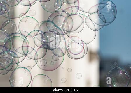 Soap bubbles on a blurred background. Lots of rainbow bubbles connecting with each other. The abstract background. Stock Photo