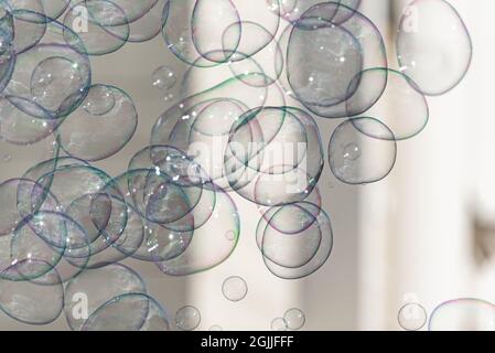 Soap bubbles on a blurred background. Lots of rainbow bubbles connecting with each other. The abstract background. Stock Photo