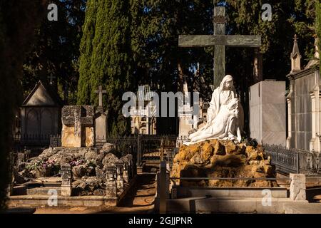 View of graves in a quiet and empty old cemetery during the day. Stock Photo