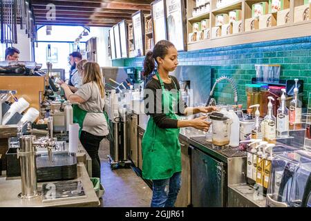 London England,UK Bloomsbury,Starbucks Coffee counter,barista baristas preparing drinks order Black African female girl teen teenager worker working Stock Photo