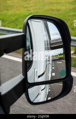 Road view from the side mirror. Traveling by car Stock Photo
