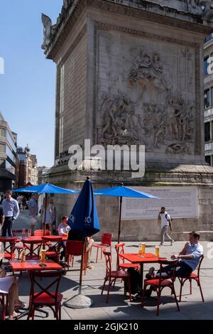 In the week that many more Londoners returned to their office workplaces after the Covid pandemic, workers enjoy after-hours drinks beneath the historic 'Monument' in the City of London, the capital's financial district, on 8th September 2021, in London, England. Monument marks the approximate location where where the Great Fire of London is said to have started in 1666. Stock Photo