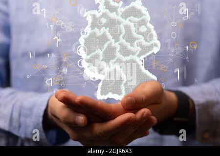 Shot of the Germany map concept surrounded by bits over human hands Stock Photo