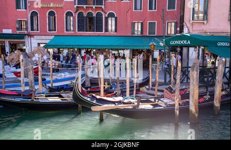 Gondolas on the Grand Canal in Venice. The canal runs from the Santa Lucia railway station to the lagoon at San Marco. Tourists like to take Gondolas. Stock Photo