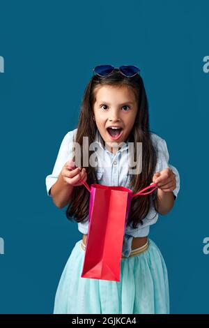 happy little caucasian child girl holds many shopping bags Stock Photo