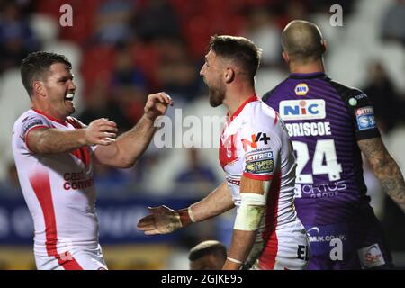 St Helens' Tom Makinson (centre) celebrates scoring their side's fourth try of the game during the Betfred Super League match at the Totally Wicked Stadium, St Helens. Picture date: Friday September 10, 2021. Stock Photo