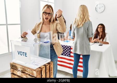 Group of young girls voting at democracy referendum angry and mad raising fist frustrated and furious while shouting with anger. rage and aggressive c Stock Photo