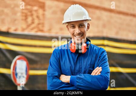 Young caucasian worker smiling happy wearing uniform at the city. Stock Photo