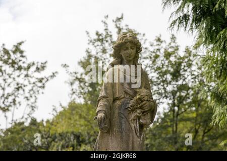 A stone statue of a standing woman, on a grave at Arnos Vale Cemetery, Bristol UK, 02-09-2021. Stock Photo