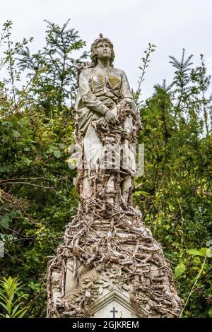 A stone statue of a standing woman, on a grave at Arnos Vale Cemetery, Bristol UK, 02-09-2021. Stock Photo