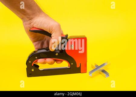 a stapler for upholstery in your hand, staples for a stapler.  Stock Photo